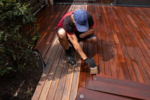 Deck Painting. Deck painting Worker Applying paint With A brush.