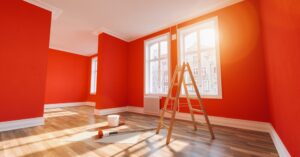 Interior Painting. Painting wall red in room after restoration or refurbishment.